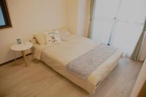 a small bedroom with a bed and a table at SN3A 大須徒歩10分 TV,パソコンなど設備充実 木の温もりあるナチュラルな部屋 8人可 10-minute walk to Osu Fully equipped with TV, PC, etc Natural wooden warm rooms Accommodates 8 people in Nagoya