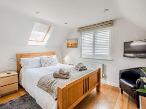 Un dormitorio con una cama, un televisor y una silla. en 3 Bed in Brockenhurst 55301, en Brockenhurst