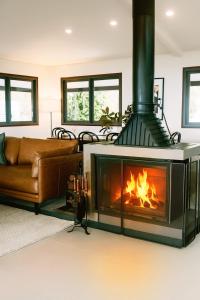 BooroobinにあるMaleny Scenic Retreatのリビングルーム(暖炉、ソファ付)