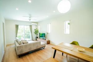 a living room with a couch and a table at Villa NIRAI in Uruma