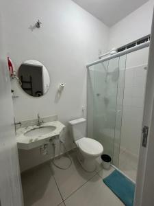 a bathroom with a toilet and a sink and a shower at Estadia Luz & Fé in Cachoeira Paulista