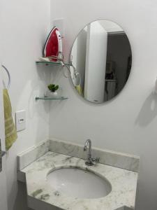 a bathroom with a sink and a mirror at Estadia Luz & Fé in Cachoeira Paulista