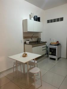 a kitchen with a table and chairs and a stove at Estadia Luz & Fé in Cachoeira Paulista