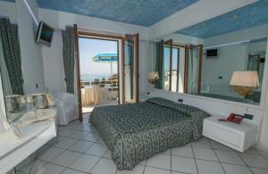een slaapkamer met een bed en uitzicht op de oceaan bij Hotel Ristorante Panoramico in Castro di Lecce