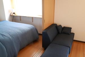 a bedroom with a bed and a couch at SN4C 和洋くつろぎの空間 大須 鶴舞駅最寄り 栄まで徒歩圏内 最大6名 Japanese and Western Relaxing Space Closest to Osu Tsurumai Station Within walking distance to Sakae Maximum 6 people in Nagoya