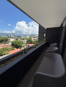 een balkon met stoelen en uitzicht op de stad bij Escalon apartment in San Salvador