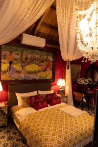 Buôn Ja Ea KuătにあるCochinchine Jardin - Retreat Art Museum Insideのベッドと壁に絵が飾られた寝室