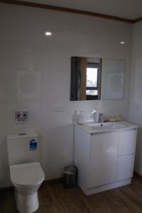 a white bathroom with a toilet and a sink at Mount Rumney Escapes - 4 Seaview Devil House in Mount Rumney +34 photos