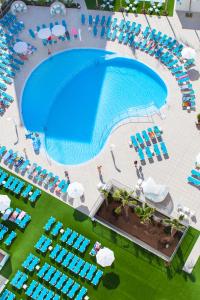 a beach with a lot of lawn chairs and umbrellas at Port Benidorm Hotel & Spa 4* Sup in Benidorm