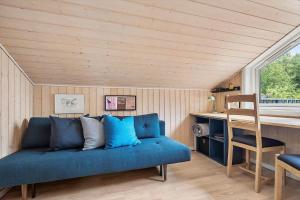 a living room with a blue couch and a desk at 20409-Samso-Nylandsvej-21-A in Ballen