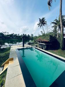a swimming pool with a view of a body of water at Wintergreen Water Front Resort in Tripunnittara