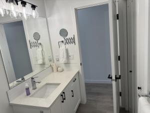 a white bathroom with a sink and a mirror at Lake and Vine in Kelowna