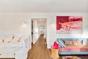 a living room with a couch and a painting on the wall at Lady Rose Cottage Jamberoo in Jamberoo