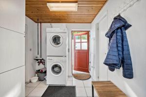 a laundry room with a washing machine and a red door at AE216-Marstal-Hovedgaden-27 in Marstal +16 photos