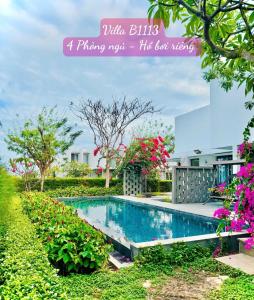 a picture of a swimming pool in a garden at Oceanami Villas & Beach Club in Long Hai