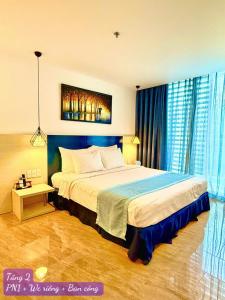 a bedroom with a large bed with blue curtains at Oceanami Villas & Beach Club in Long Hai +26 photos