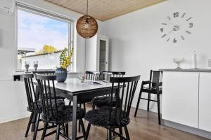 een keuken met een tafel en stoelen en een klok bij SB50301-Sydals-Solbjergvej-7 in Sønderby
