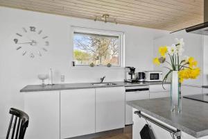 een keuken met witte kasten en een klok aan de muur bij SB50301-Sydals-Solbjergvej-7 in Sønderby +10 foto's