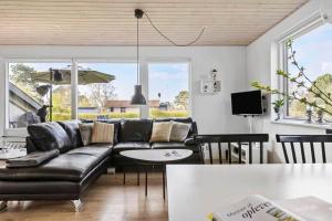 een woonkamer met een zwarte leren bank en een tafel bij SB50301-Sydals-Solbjergvej-7 in Sønderby