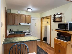 a kitchen with wooden cabinets and a counter top at Cozy Downtown Hunter Mountain Getaway in Hunter +8 photos