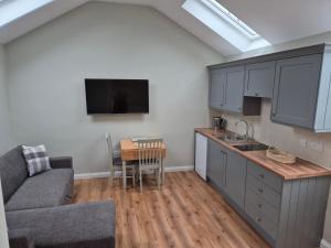 a kitchen with a couch and a table in a room at Barn on the Farm Holiday Lets in Magherasaul