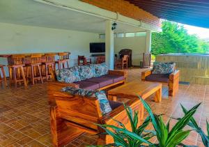 a patio with couches and a table and a bar at Finca VIP de lujo privada, jacuzzi y paz cerca de la piedra de Guatape in Guatapé