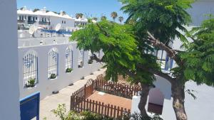 a white building with a tree in front of it at Playmar Sun Maspalomas in Playa del Ingles