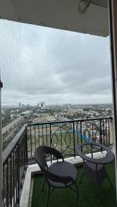 Un balcón con dos sillas y vista a una ciudad. en High sky in, en Greater Noida