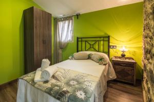 a bedroom with a bed with green walls at Casa Carla in Palas de Rei