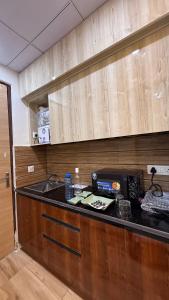 Una cocina con encimera negra en una habitación. en High sky in, en Greater Noida