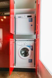 Una lavadora y secadora en una habitación roja en Casa Carla, en Palas de Rei 