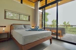 a bedroom with a bed and a balcony at Yume17 in Chaloklum +22 photos