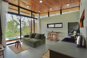 a kitchen and living room with a couch and a table at Yume17 in Chaloklum