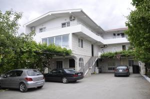 two cars parked in a parking lot in front of a house at Guest House Lalic in Bar