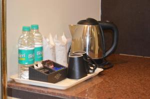 une bouilloire et des tasses sur un comptoir avec des bouteilles d'eau dans l'établissement Grandeur De Sanchi Resort, à Calangute 32 autres photos