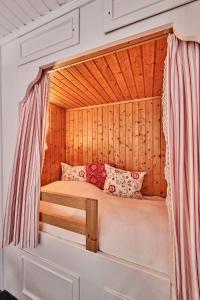 a small bed in a room with a wooden wall at Dünengras in Cuxhaven