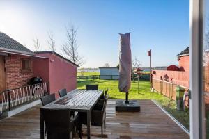 a wooden deck with a wooden table and a umbrella at AE287-Marstal-Kirkevejen-38 in Marstal
