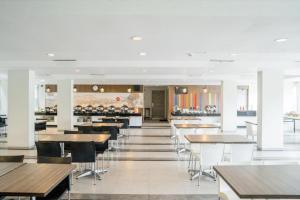 a restaurant with tables and chairs and a bar at Amaris Hotel Ambon in Ambon