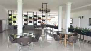 a restaurant with two tables and chairs in a room at Aries Biru Hotel & Villa in Kopo 2