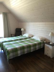 1 dormitorio con 1 cama con manta verde y blanca en Rauha Marina 5 en Imatra