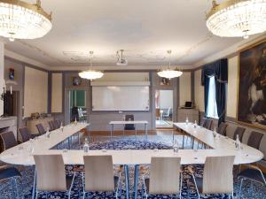 una sala riunioni con un grande tavolo bianco e sedie di Noors Slott a Knivsta