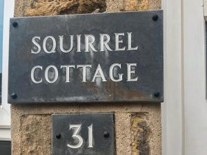 a street sign for a squirrel cottage on a building at Squirrel Cottage in Filey
