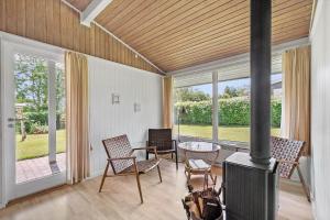 SB50367-Nordborg-Sildestien-1 في نُوابورغ: غرفة معيشة بها موقد وطاولة وكراسي