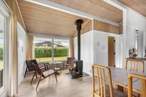 SB50367-Nordborg-Sildestien-1 في نُوابورغ: غرفة طعام مع طاولة وكراسي ومدفأة