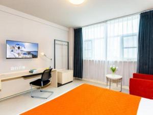 a living room with a red couch and a desk at Jinjiang Inn Sanya Hexi Road Pedestrian Bridge in Sanya