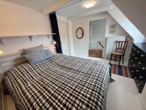 a bedroom with a bed with a checkered blanket at AE261-Aeroskobing-Sondergade-50 in Ærøskøbing