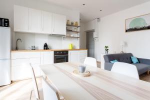 una cucina con mobili bianchi, tavolo e sedie di Diderot - Beautiful Cosy Apartment in Grenoble - Gare a Grenoble Altre 9 foto