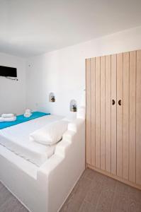 a white bedroom with a large white bed and cabinets at Marina's House in Tourlos