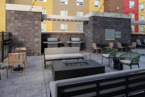 a patio with chairs and a couch and tables and chairs at Home2 Suites By Hilton West Lafayette in West Lafayette