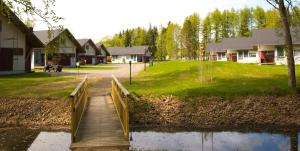 a wooden bridge over a pond in a village at Holiday Linnunlahti in Joensuu